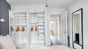 A bedroom with a large closet, a bed with a striped pillow, and a hallway leading to another room. - Modern Waterloo 1BR w/ open plan on Lower Marsh, by Blueground (London)