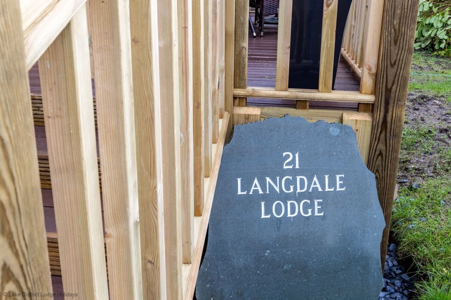 A wooden deck leading to a lodge entrance with a sign reading "21 LANGDALE LODGE".