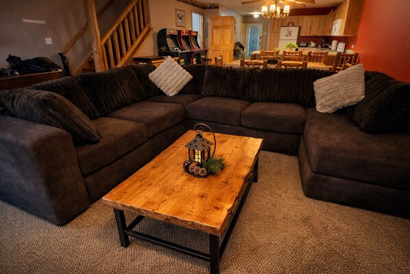 A cozy living room with a sectional sofa, a wooden coffee table, and a decorative lantern.