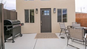 Un patio con una parrilla, una puerta y un área de estar.
