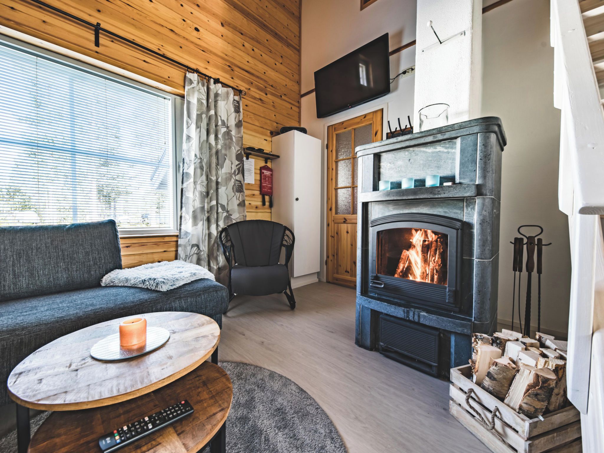 Un salon chaleureux avec une cheminée, un canapé, un fauteuil et une table basse.