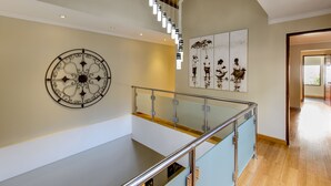 Ein modernes Interieur mit Glastrennwand, einer Wanddekoration und einer Treppe.
