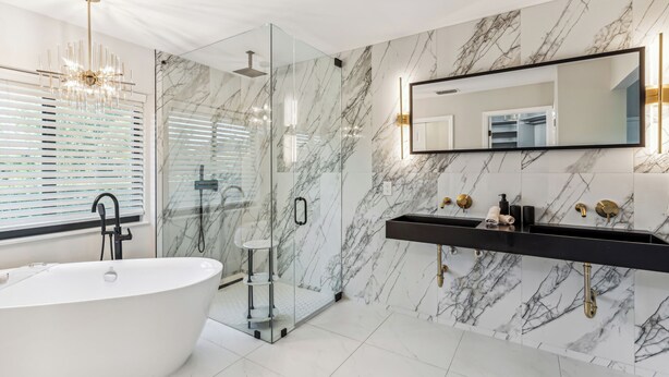 A modern bathroom with a freestanding bathtub, a glass-enclosed shower, and a marble backsplash. - Luxury fully rehabed house with Lake View (Naples)