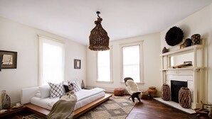 Un dormitorio con cama, chimenea y un ventanal grande.
