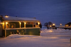 A two-story building with a snow-covered roof and a small porch area.