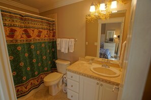 A bathroom with a toilet, sink, and mirror.