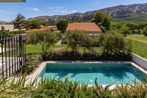 Une piscine offrant une vue sur un quartier résidentiel et, au loin, sur des montagnes.