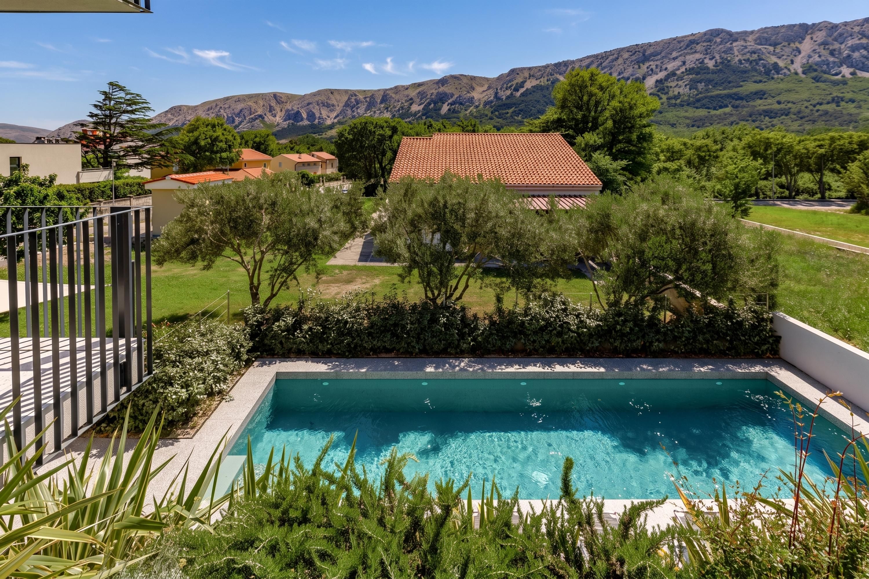A swimming pool with a view of a residential area and mountains in the background.