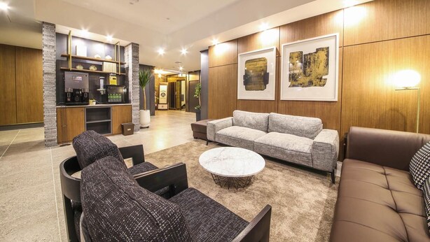 A modern living room with a sofa, armchairs, a coffee station, and artwork on the walls. - Gupo Brown-Dot Hotel (Busan)