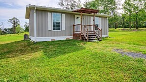 A single-story mobile home with a covered porch and a small front yard.