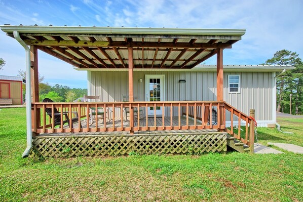 A small, single-story building with a covered porch and a fenced yard.