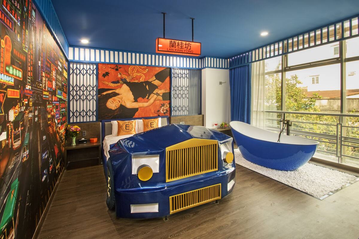 A modern room with a unique blue and yellow design, a large window with a view, and a decorative wall mural.