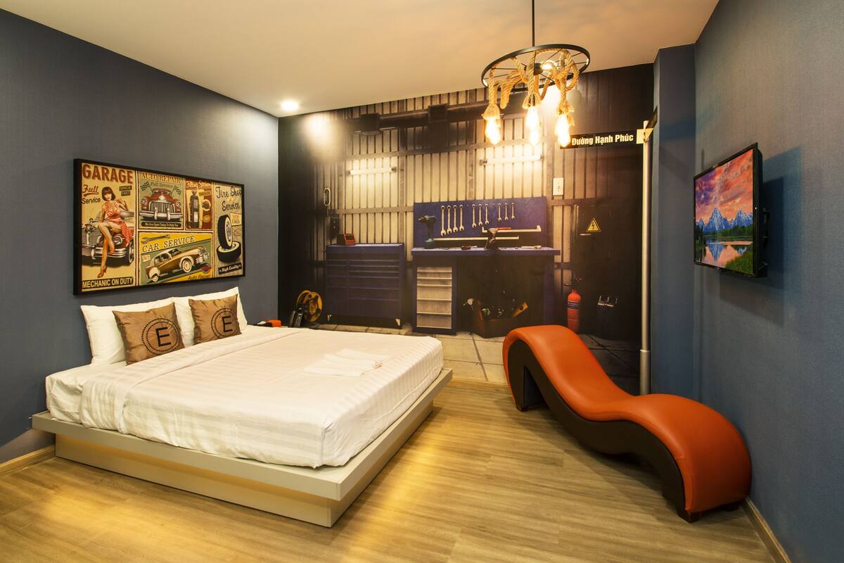 A modern bedroom with a large bed, a desk, and a chair.