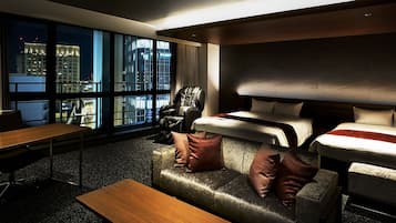 A modern hotel room with a large window offering a city view, a sofa with cushions, a bed with pillows, and a wooden table.