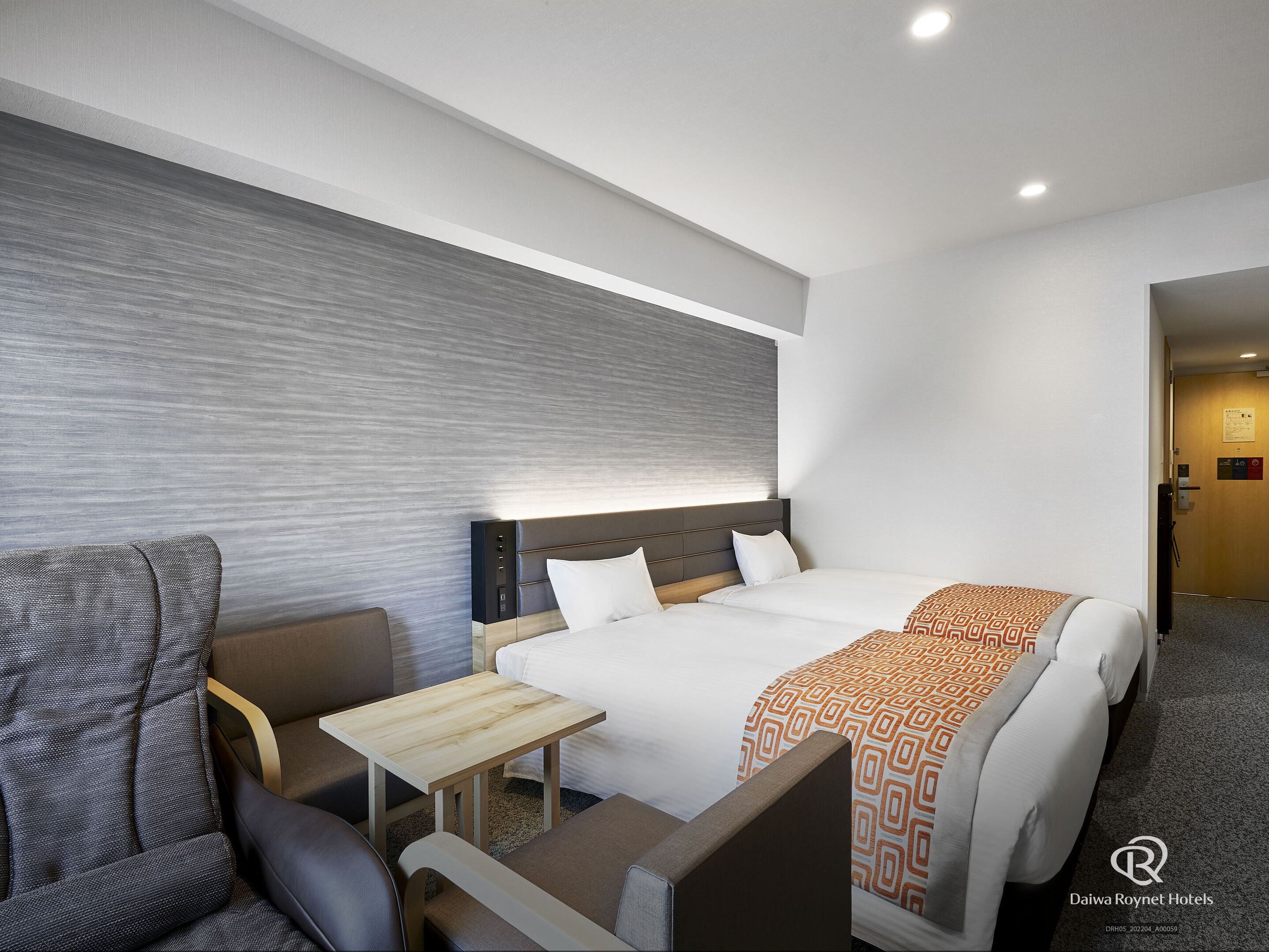 Une chambre d’hôtel avec un grand lit, un bureau, une chaise et un canapé.