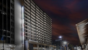 A high-rise hotel with multiple balconies, a modern architectural design, and a well-lit facade.