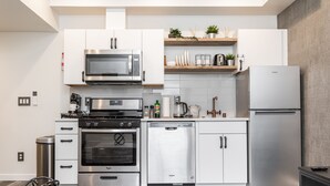 A modern kitchen with stainless steel appliances, white cabinetry, and a built-in dishwasher. - ⚡️The Brooklyn⚡️CENTRAL Capital Hill with Perfect Walking score🚶🏻‍♂️with Rooftop views (Seattle)