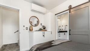 A bedroom with a bed, a wardrobe, a mirror, and a small table with a vase. - ⚡️The Brooklyn⚡️CENTRAL Capital Hill with Perfect Walking score🚶🏻‍♂️with Rooftop views (Seattle)