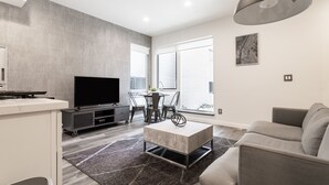 A modern living room with a flat-screen TV, a coffee table, and a sofa. - ⚡️The Brooklyn⚡️CENTRAL Capital Hill with Perfect Walking score🚶🏻‍♂️with Rooftop views (Seattle)