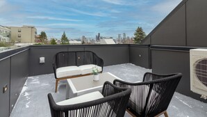 A rooftop terrace with a view of a city skyline, featuring a table and two chairs. - ⚡️The Brooklyn⚡️CENTRAL Capital Hill with Perfect Walking score🚶🏻‍♂️with Rooftop views (Seattle)