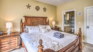 A neatly made bed with a wooden headboard, two bedside tables with lamps, and decorative wall art. - Magnolia Pointe Condo with Community Pool & More! (Myrtle Beach)