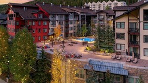 A hotel with multiple floors, outdoor seating areas, and a pool.