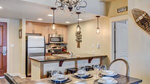 A modern kitchen with a central island, stainless steel appliances, and pendant lighting.