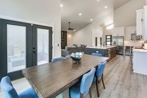 Une cuisine moderne avec un coin repas, un ventilateur de plafond et une grande fenêtre.