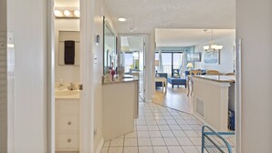 A modern kitchen with a central island, a dining area with a blue sofa, and a view of the sea through large windows. - *Fall into Savings-20% Off New Bookings thru 2026* (Murrells Inlet)
