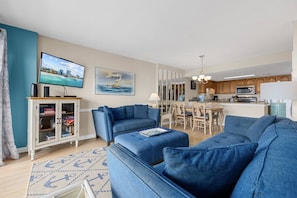 A living room with a blue sofa, a television, and a bookshelf.