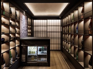 A bar area with shelves of bottles and a refrigerated display. - KYOTO GRANBELL HOTEL hanareya (Kyoto)