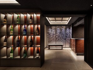 A modern interior with a wall-mounted liquor display, a bench, and a decorative wall with a tree branch motif. - KYOTO GRANBELL HOTEL hanareya (Kyoto)