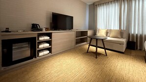 A modern hotel room with a flat-screen TV, a coffee maker, a sofa, and a small table. - KYOTO GRANBELL HOTEL hanareya (Kyoto)