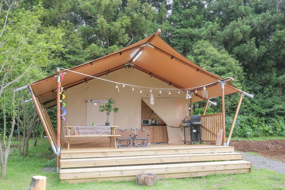 Une cabane en bois comprenant un coin cuisine, une table à manger et un espace salon.