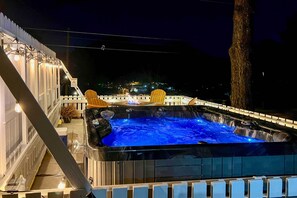 Relax in a serene hot tub surrounded by a white fence and comfortable seating.