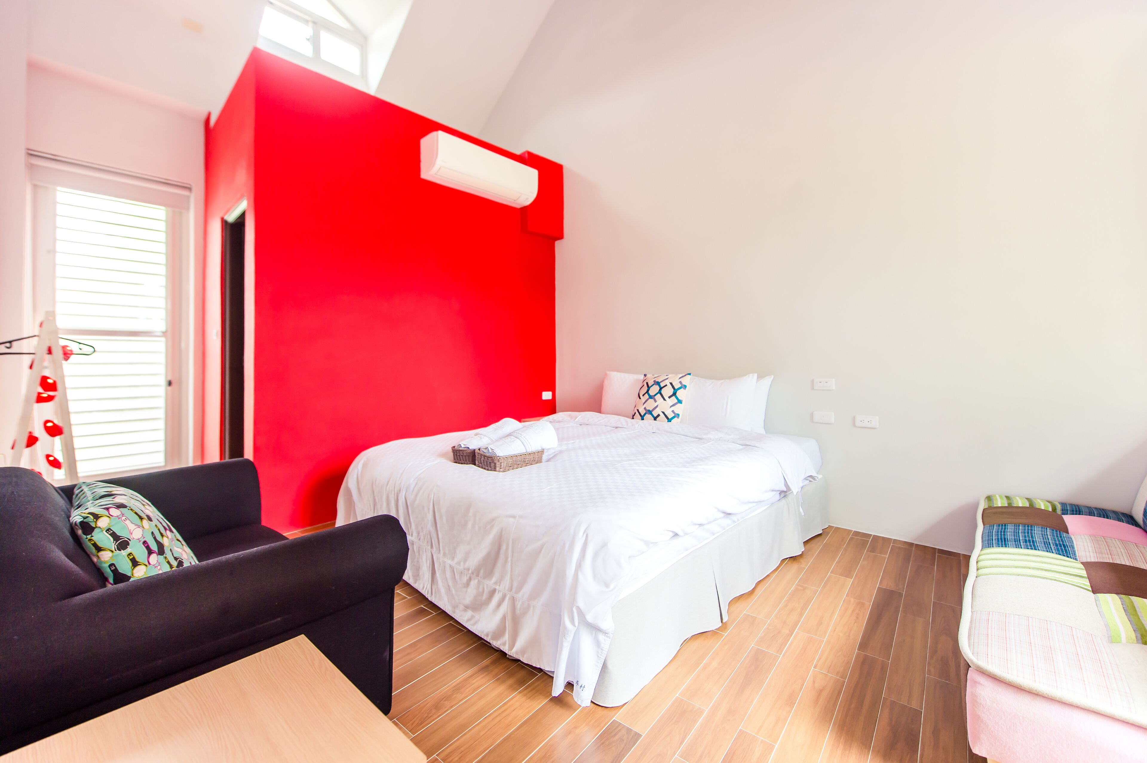 A bedroom with a large bed, a sofa, and a small table.
