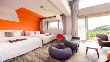 A modern hotel room with two beds, a sofa, a red chair, and a balcony with a view of greenery.