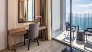 A hotel room with a desk, chair, and a view of the sea. - Panorama Luxstay Nha Trang (Nha Trang)