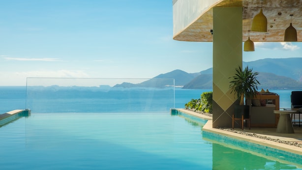 An infinity pool with a clear view of the sea and mountains in the background. - Panorama Luxstay Nha Trang (Nha Trang)