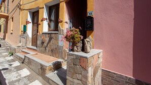 A building with a stone staircase leading to a door, a mailbox, and a flower arrangement on the steps.