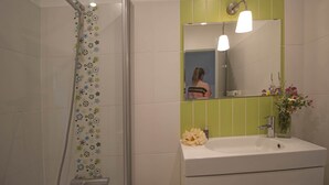 A bathroom with a shower, a sink, and a mirror.
