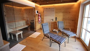 Un interior de madera con dos sillas de mimbre, un banco y una puerta.