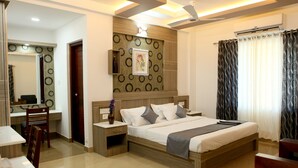 A modern hotel room with a large bed, bedside tables, a desk, and a chair.