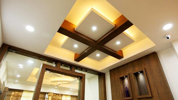 A modern ceiling with recessed lighting and wooden beams.