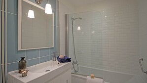 A bathroom with a sink, mirror, and shower. - Maison du Prunier (N°5) (Marcorignan)