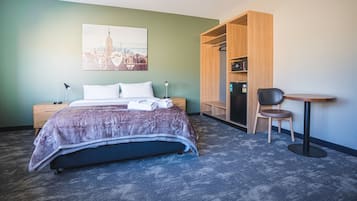 Espacio para trabajar con laptop y tabla de planchar con plancha