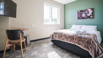 Espacio para trabajar con laptop y tabla de planchar con plancha