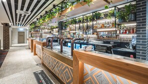 A bar area with a counter, shelves of bottles, and hanging plants. - The Peakhurst (Peakhurst)