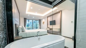 A modern bathroom with a freestanding bathtub, a glass shower enclosure, and a large mirror.