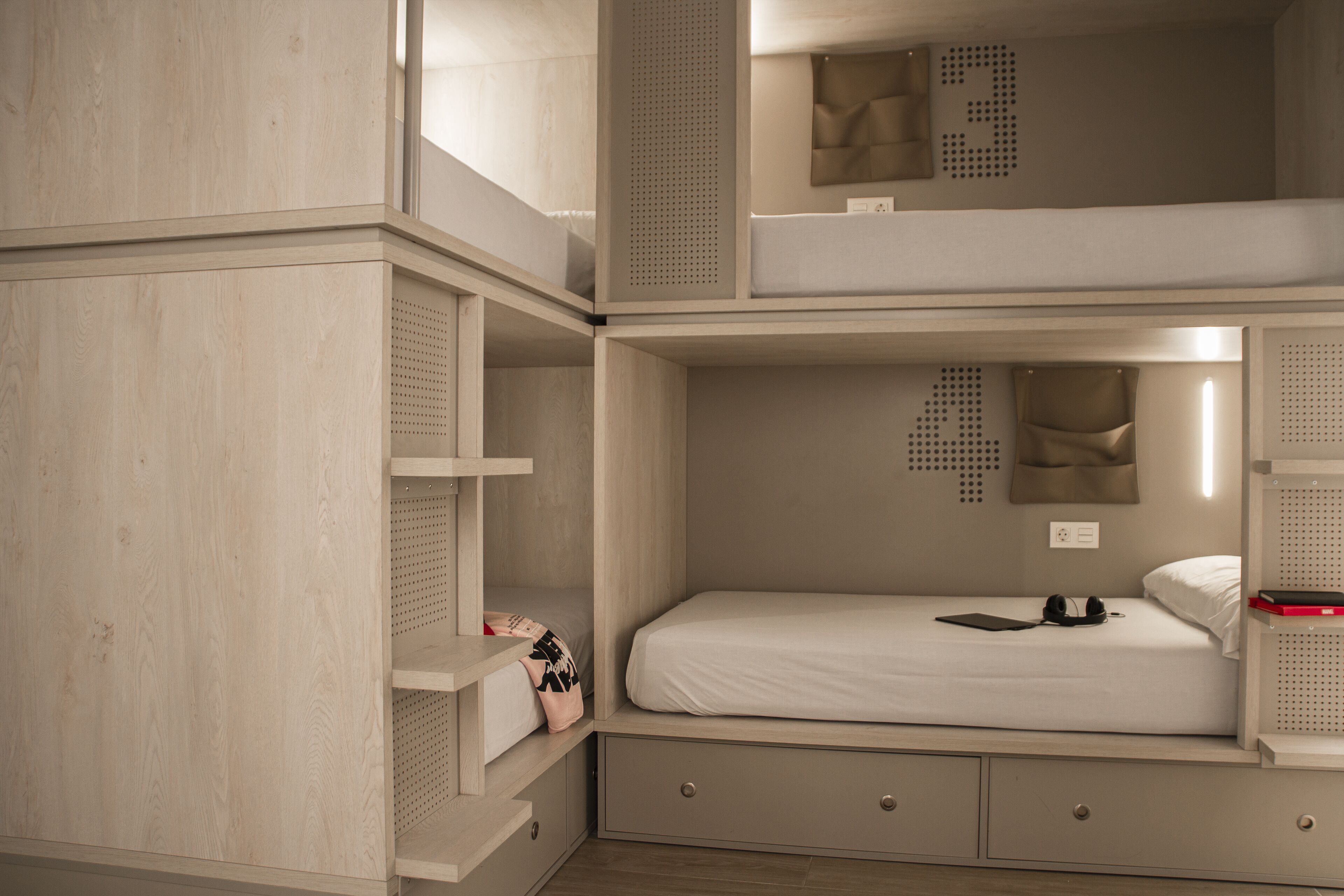 Habitación con literas, un escritorio y cajones.